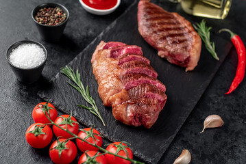 Two grilled picanha steaks with spices on a stone background
