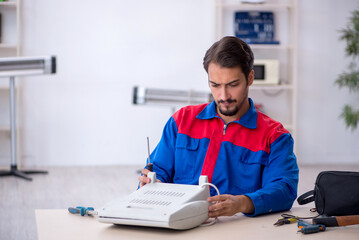 Obraz na płótnie Canvas Young male repairman repairing heater
