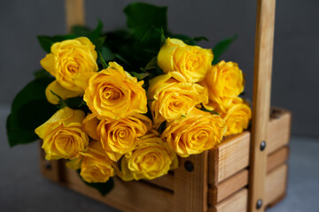 Bouquet of yellow roses on a gray background.