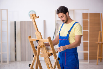 Young male repairman repairing easel at home