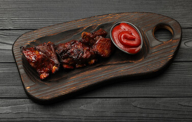 Barbecue spare ribs and BBQ sauce on wooden board