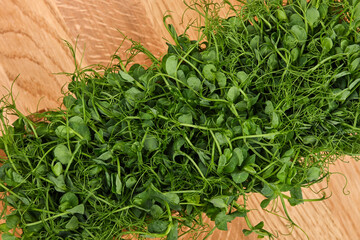 Green peas microgreen on wooden cutting board