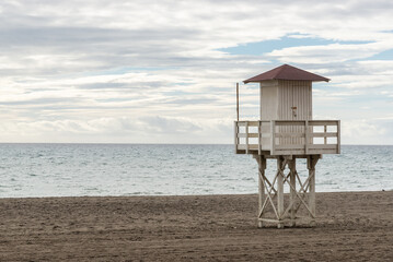 Fototapeta na wymiar Torre de vigilancia en la playa a pie del mar.