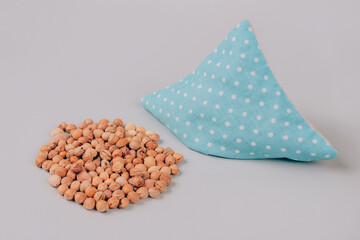Cherry pits heating pad. Cherry stone pillow on gray background with copy space. Natural heat or...
