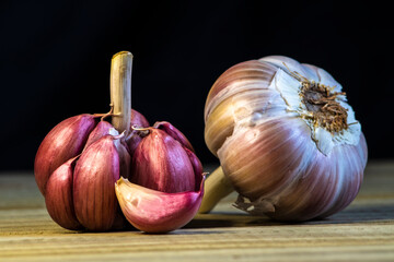 Garlic Cloves and Bulb on the wooden table and  dark background in Brazil. Copy space.