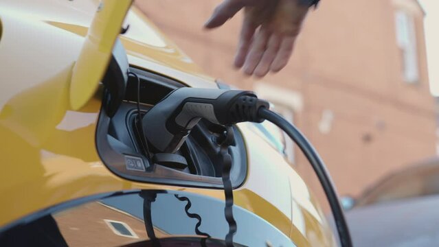 slow motion person charging electric car