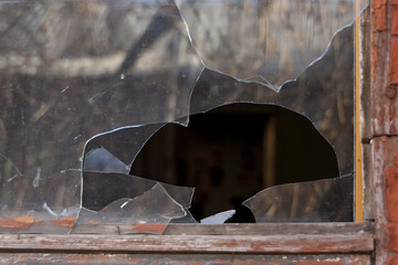 broken glass in the window of an old abandoned house, photo from outside the house