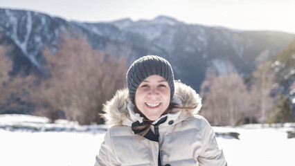 Fototapeta na wymiar Happy hispanic girl smiling on camera with snowy mountain on background - Winter concept