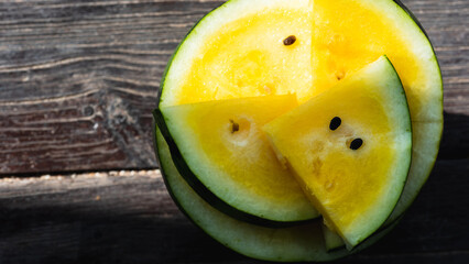 Yellow watermelon sliced on a wooden background, close up. Fruit concept