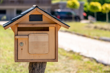 Wooden mail box with lock in garden.