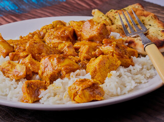 Chicken korma and rice,with naan bread at the side.