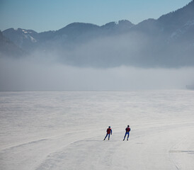 ice skaters on a frozen lake in the mountains