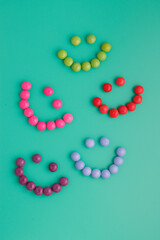 Lively, colorful candy smileys on a bright green background