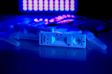 5 covid-19 antigen self-tests negative, buffer bottles and thin black-rimmed glasses on a light...