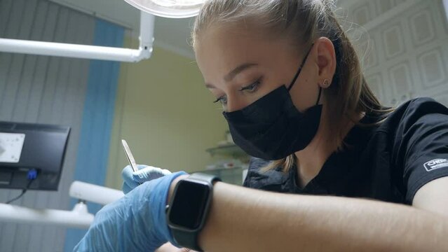 Young female dentist curing tooth cavity. Patient with caries on chair. Stomatologist and patient at clinical office. Toothcare concept