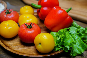 lettuce, yellow and red tomatoes and bell pepper with water drops. cucumbers.