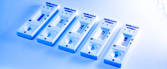 5 covid-19 antigen self-tests negative on white background. Medical concept - Mutated coronavirus...