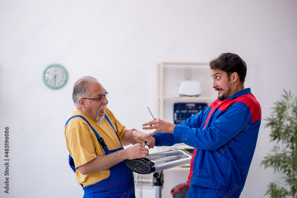 Wall mural two male repairmen working at workshop