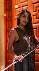 Young beautiful  girl poses outside her door with her casual outfit