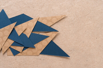 abstract paper background mostly composed with triangular shaped paper in white, blue, or brown
