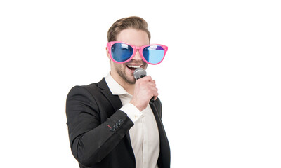 Happy funny man businessman in party glasses sing song to microphone, karaoke