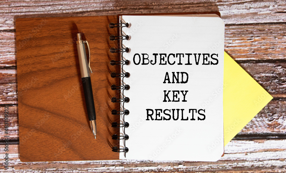 Poster objective key results okr text in the office notebook. view from above