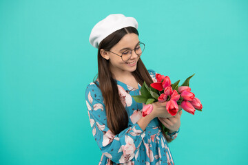 cheerful child in beret with tulips. mothers or womens day. kid in glasses