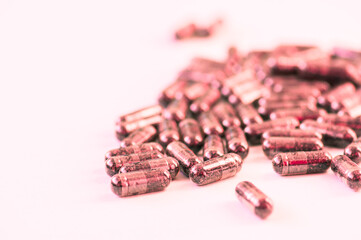 Black capsules on a pink background, Conceptual image of depression or stress.