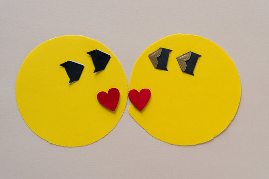 valentine or love emoji - or yellow paper circle, wooden hearts painted red on paper