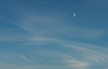 the moon in the blue sky when the sun is still setting. beautifully drawing from clouds draws. pale white blue sky with scattered cumulus clouds, Felling good-tempered relaxing sunset wallpaper. 