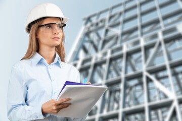 Young woman architect wearing hardhat at construction site