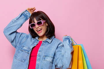 portrait woman in denim jackets with colorful shopping bags isolated background