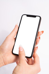 Mobile phone with blank white screen held in two hands on white background