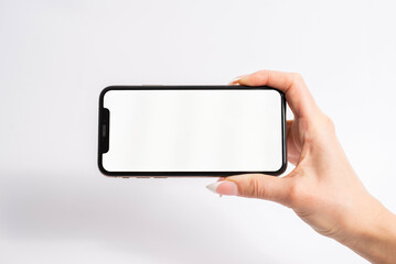 Mobile phone with blank white screen held in one hand on white background