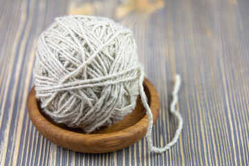 Fototapeta na wymiar A ball of thread in a wooden bowl.