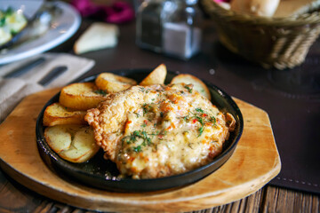 Chicken in a frying pan in a cheese hat