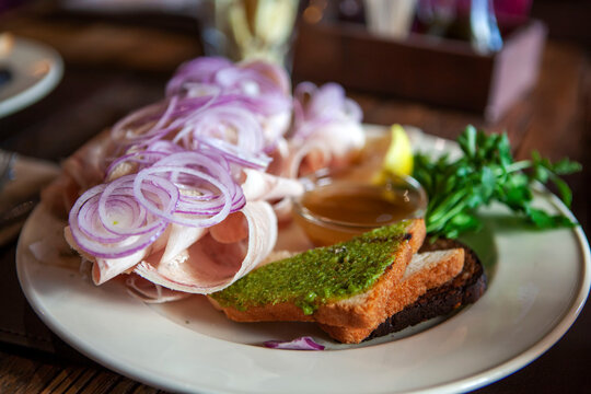 Bonito stroganina with marinated onion and olive dip toast