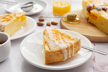Plate with slice of tasty citrus cake with oranges on table