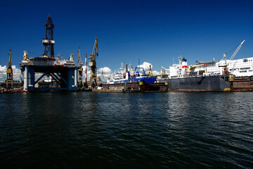 statki i wieża wiertnicza stojące w doku w stoczni - obrazy, fototapety, plakaty
