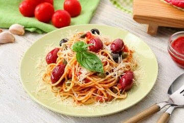 Plate of tasty Pasta Puttanesca on table in restaurant