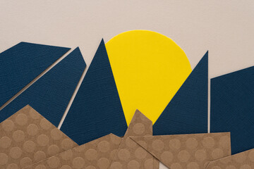 part of a yellow circle covered with triangle and polygon shapes on paper
