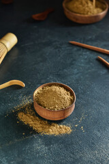 Bowl with hojicha powder on black background