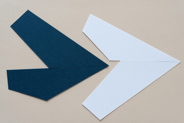 blue and white paper arrows on beige paper
