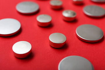 Obraz na płótnie Canvas Metal lithium button cell batteries on red background, closeup