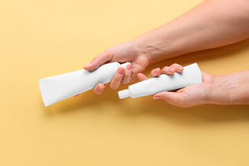 Female hands with tooth paste on beige background