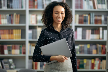 Portrait of lovely pleasant positive African American young woman, manager, freelancer or teacher...