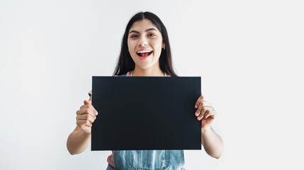 Fototapeta premium Young latin woman holding a black empty card isolated on white background in Latin America 