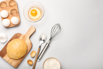 Wooden board of fresh dough for preparing walnut shaped cookies with boiled condensed milk and ingredients on light background