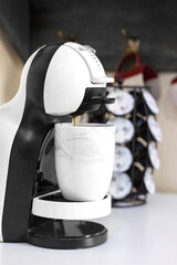 Cafetera instantánea haciendo cafe en taza tipo mármol
