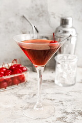 Glass of tasty Manhattan cocktail on light background